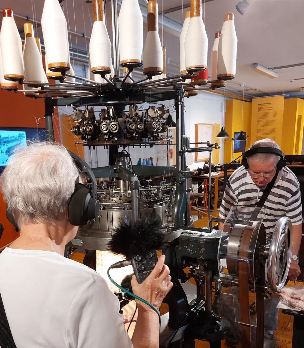 Zwei Personen machen Tonaufnahmen von einer Industriemaschine.