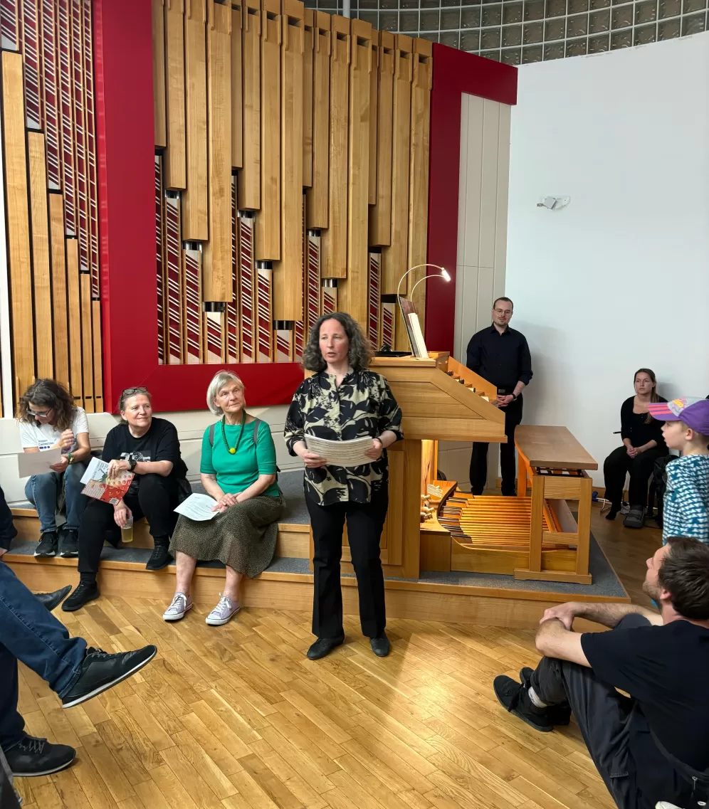 Kirsten Sturm steht vor der Orgel und moderiert