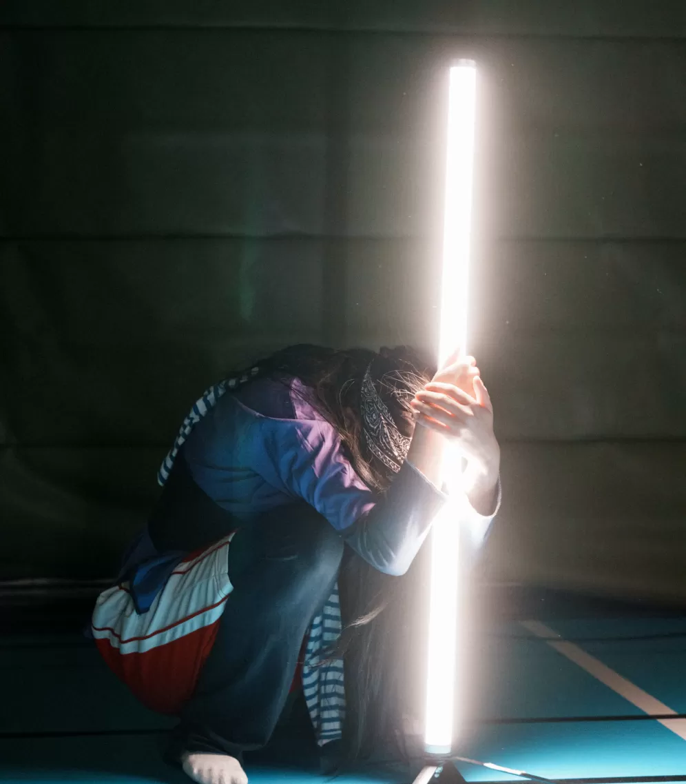 Person hiding behind light