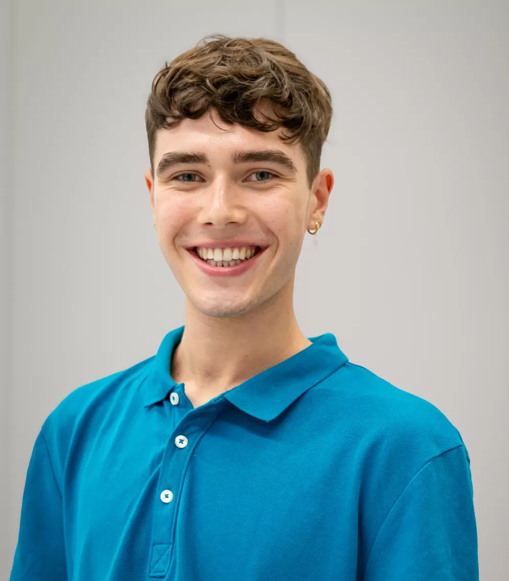 Henri is wearing a blue polo shirt and smiles warmly into the camera.