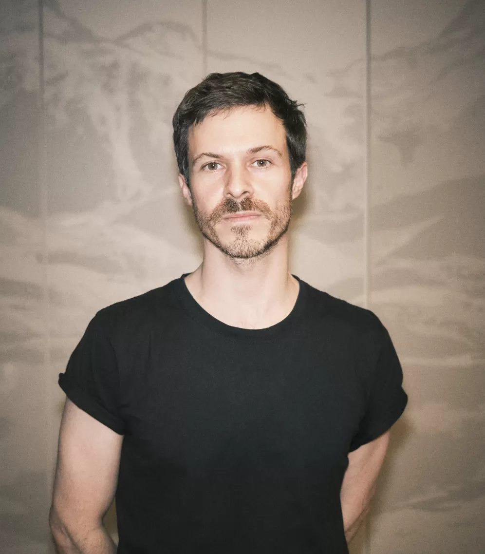 A portrait of a man wearing a black T-shirt