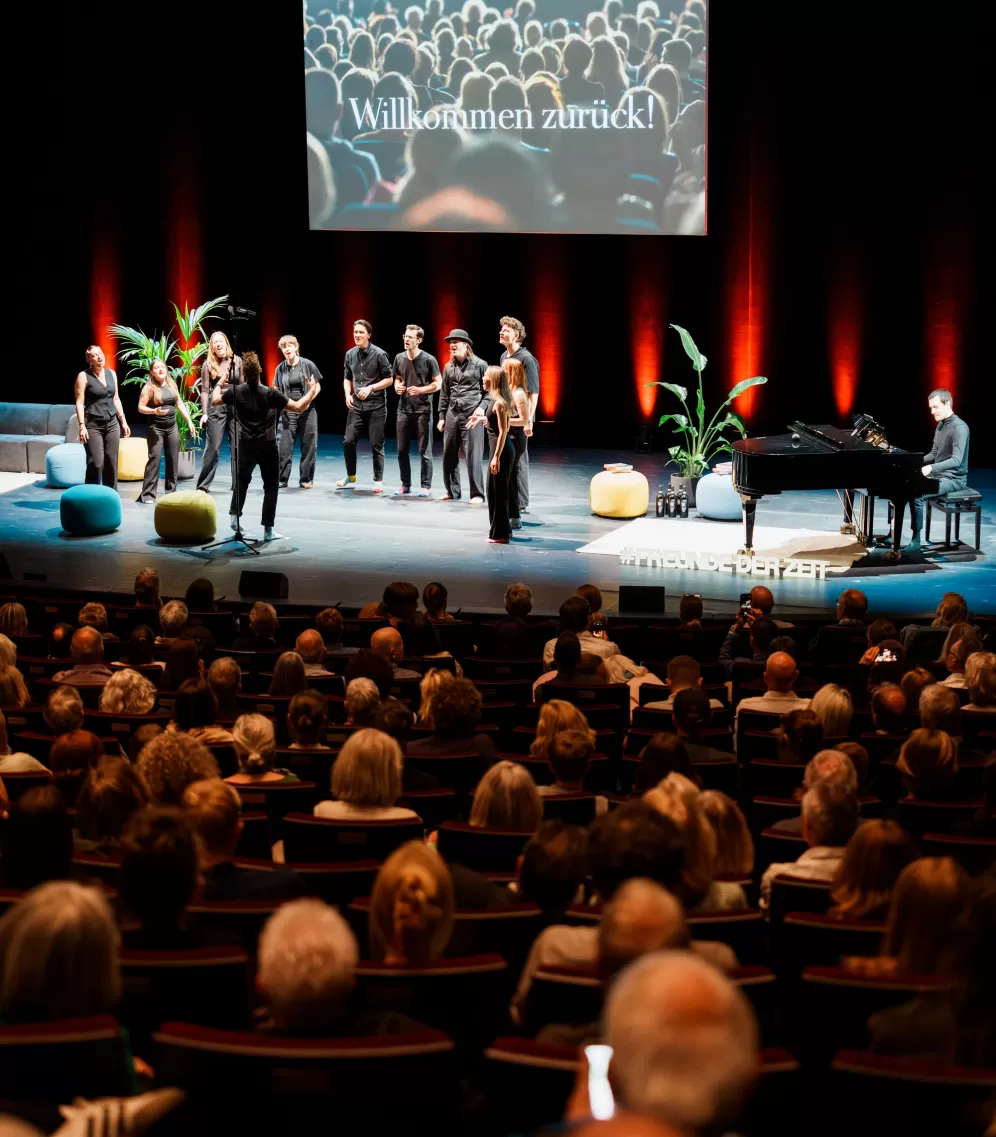 Der Pop- und Jazzchor auf der Bühne des Schauspiel Frankfurt, im Vordergrund Publikum.
