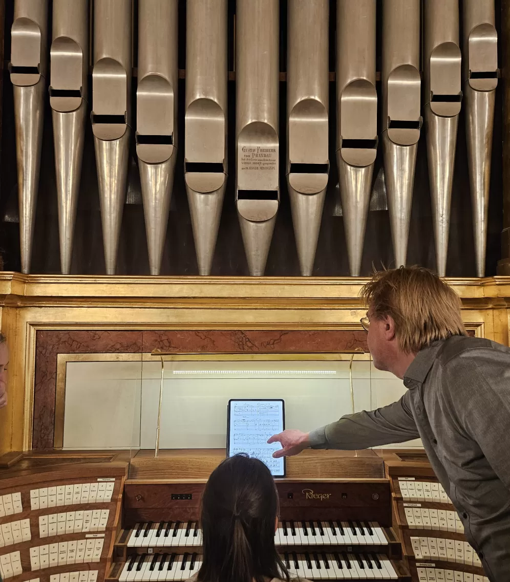 Studentin spielt an Orgel im Musikverein, Carsten Wiebusch zeigt etwas in den Noten