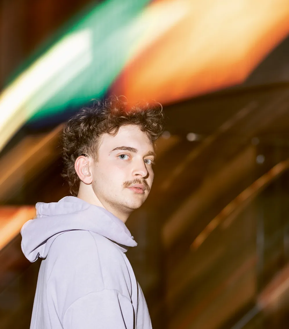 Porträt von Constantin Keller vor verschwommenen Neon-Lichtern