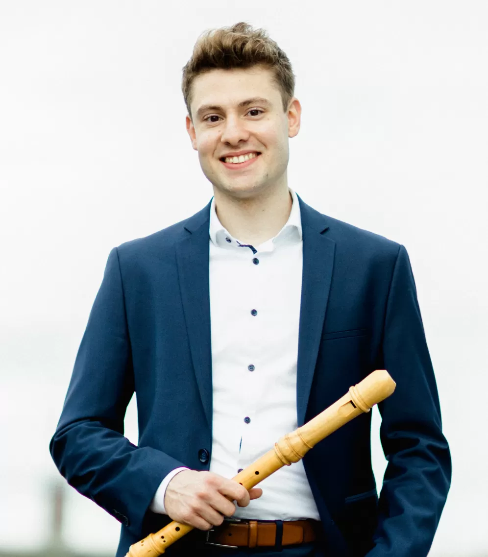 Portrait von Sebastian Schmidt mit einer Blockflöte in der Hand