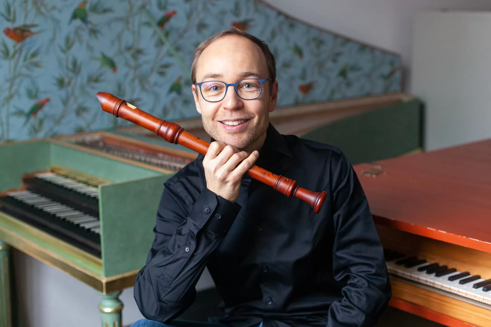 Porträt von Jan van Hoecke mit Blockflöte in der Hand vor zwei Cembalos 