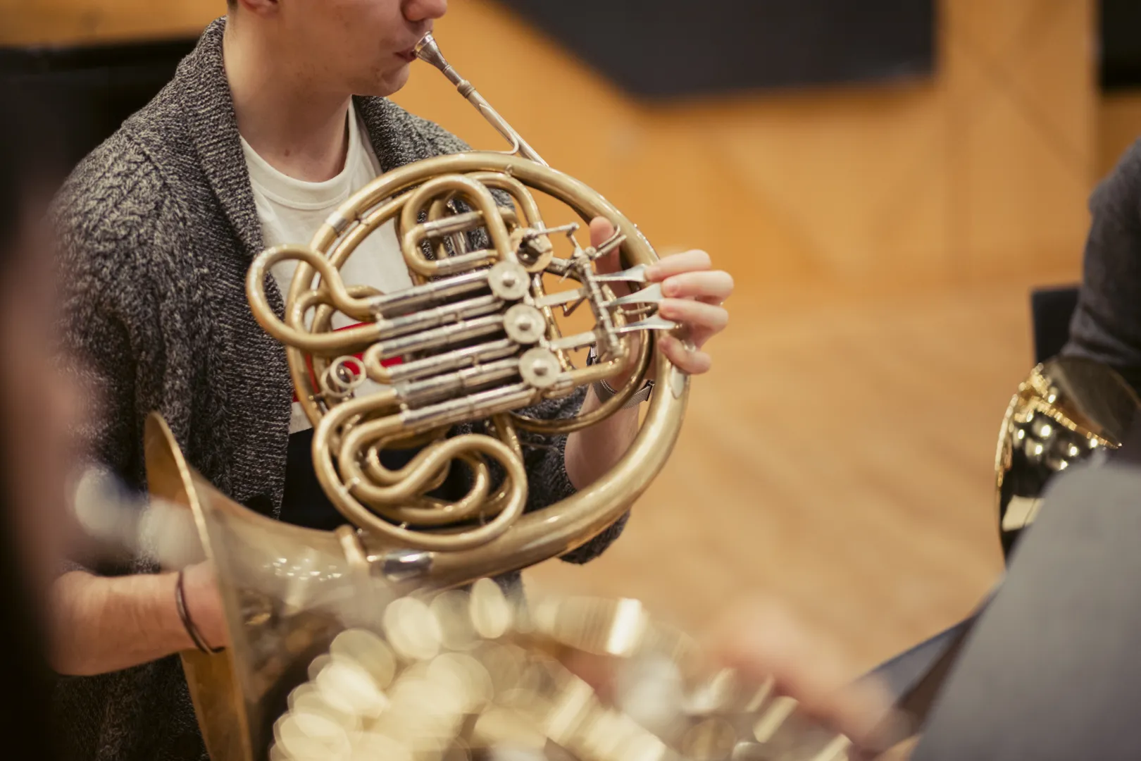 Ein Student spielt Horn in einer Ensemble-Probe.