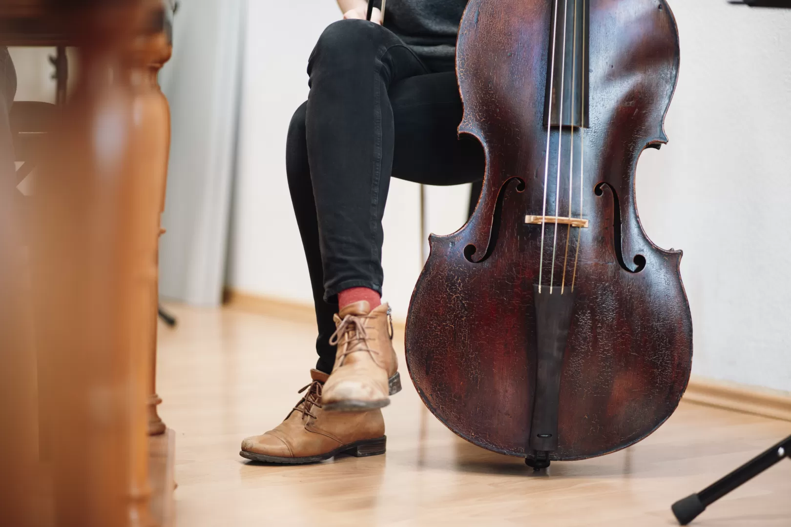 Person sitzt neben einem Barockvioloncello