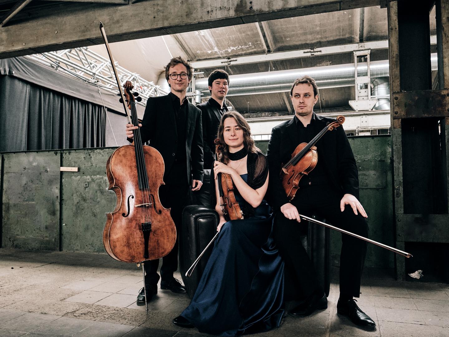 Die vier Musiker des Eliot Quartetts mit ihren Instrumenten in einer Lagerhalle.