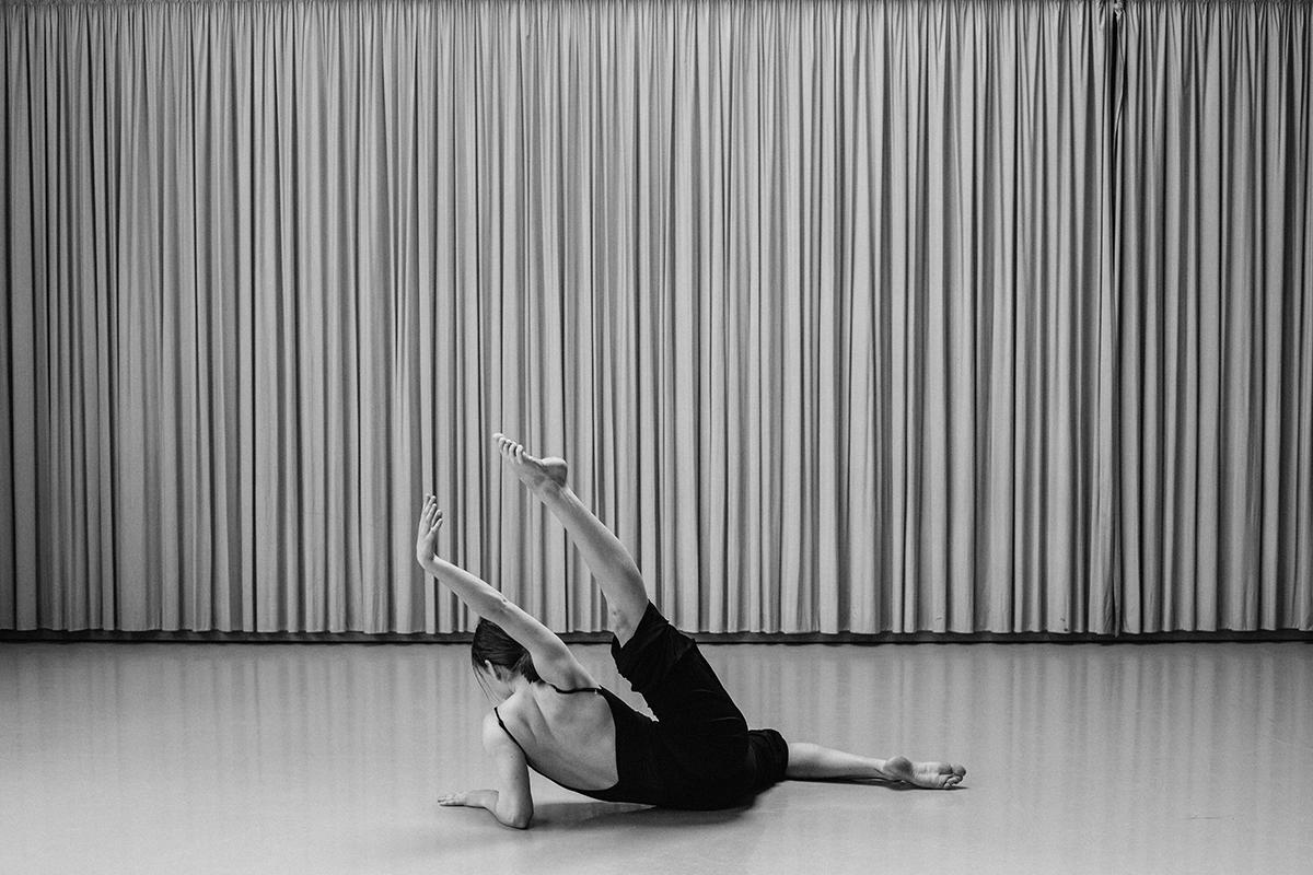 Tänzerin in einer Pose am Boden eines Tanzraums