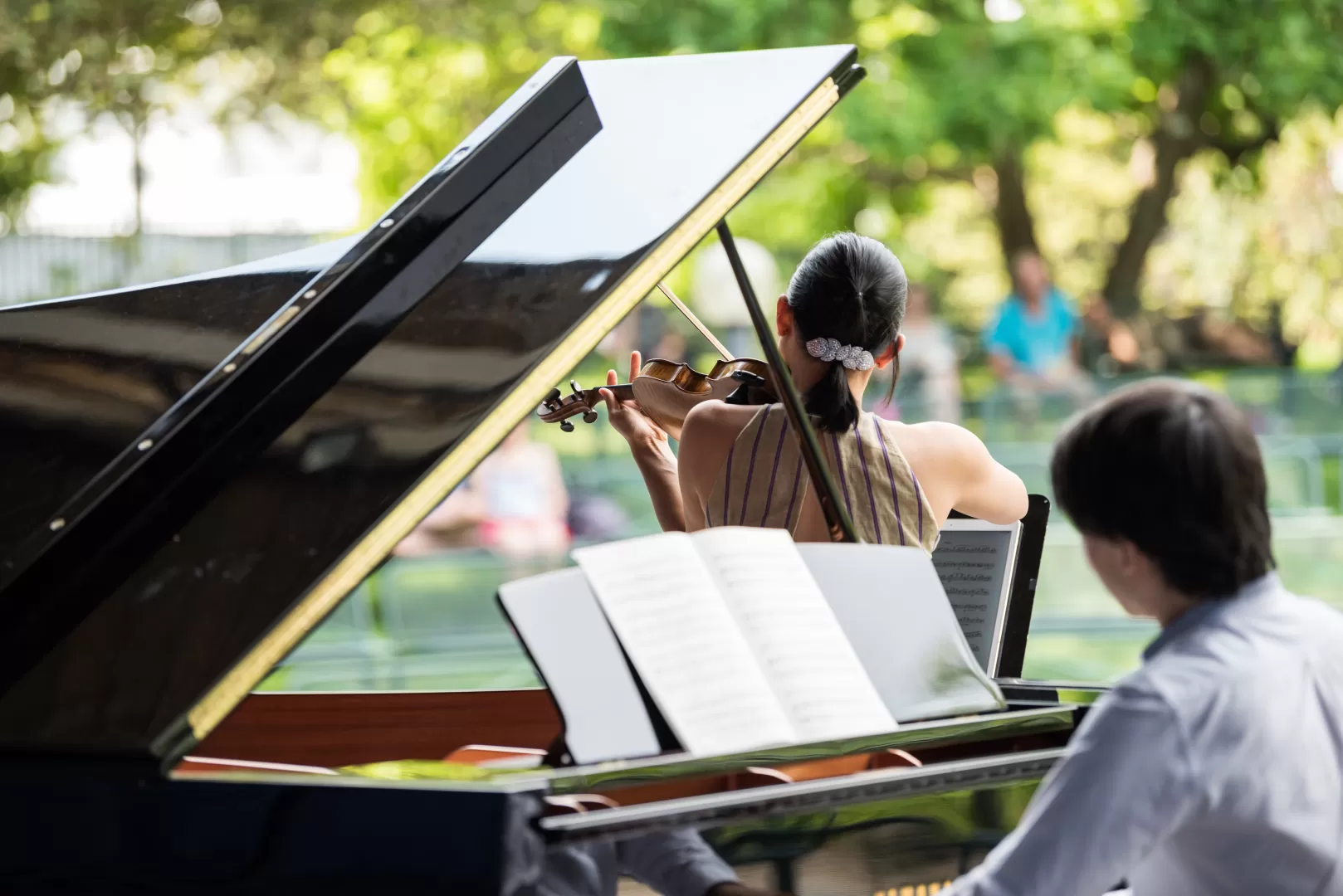 Eine Geigerin und ein Pianist auf einer Bühne im Palmengarten.