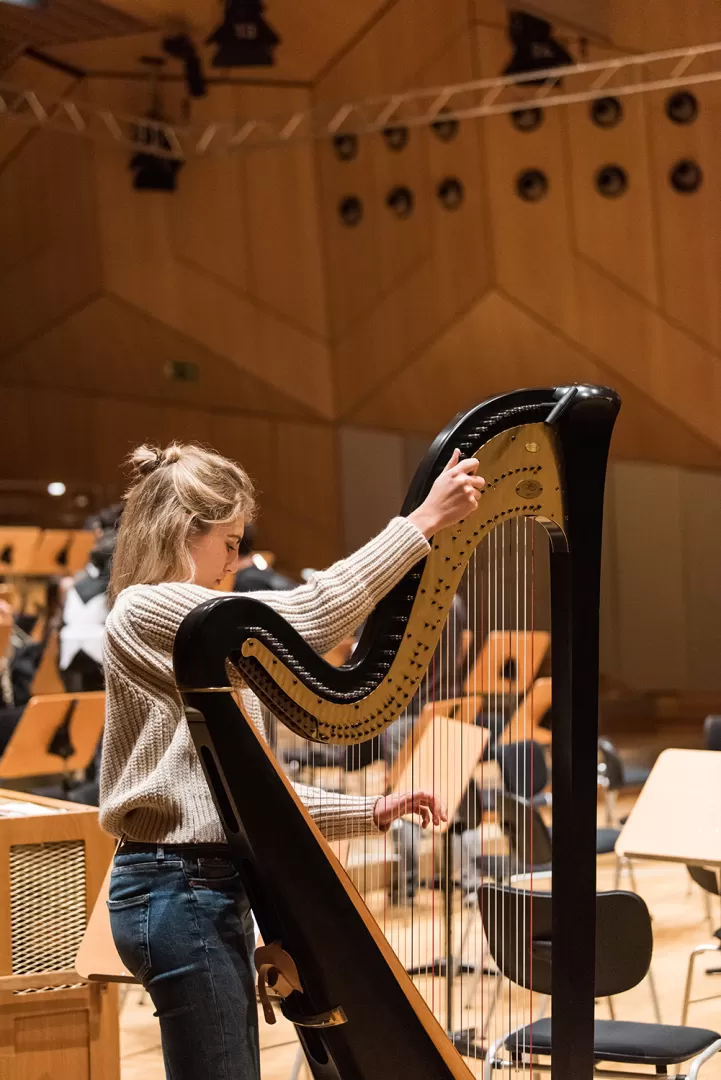 Musikerin stimmt die Harfe