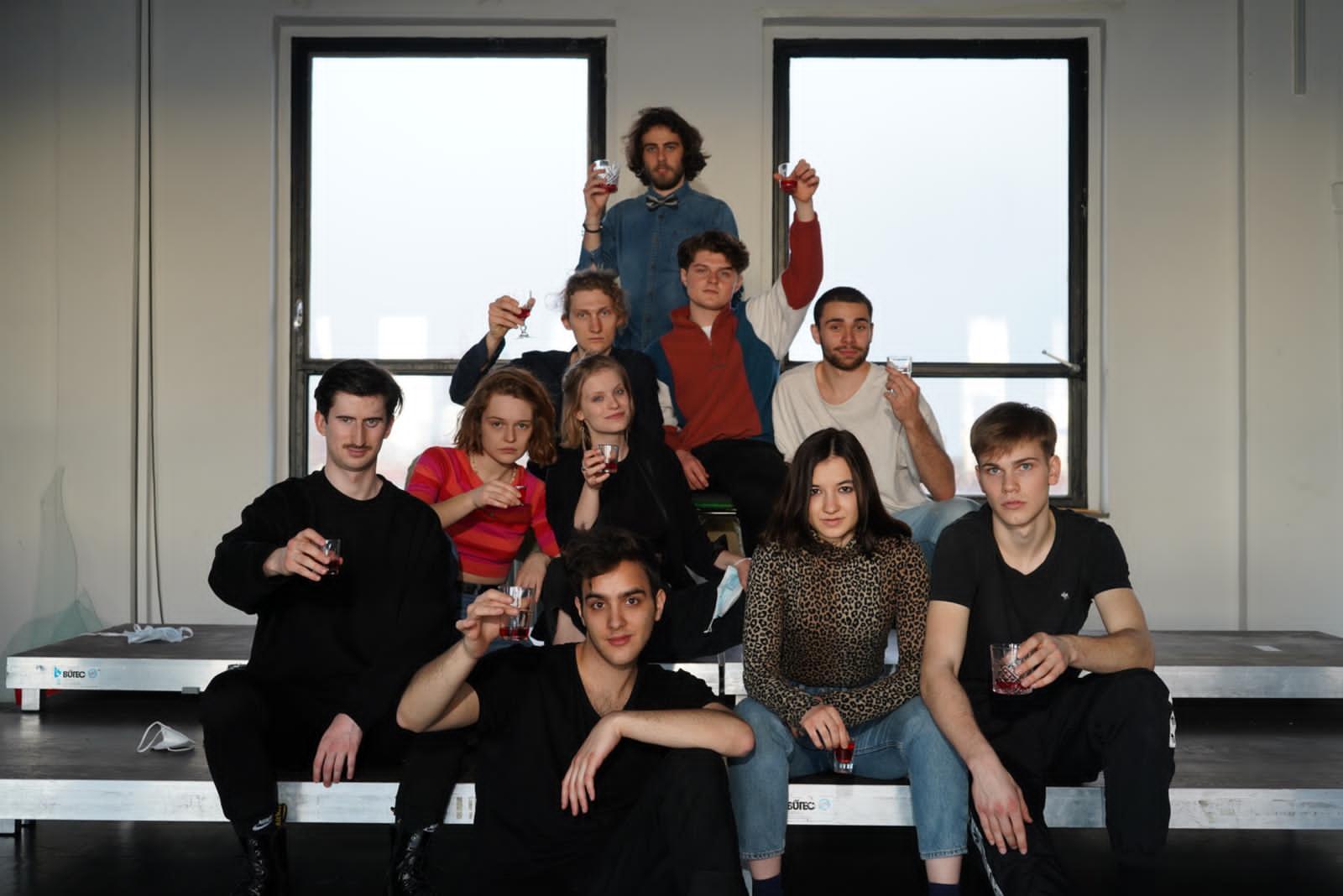 Gruppenfoto des 1. Jahrgangs Schauspiel und Regie, alle erheben ein Glas zu Kamera