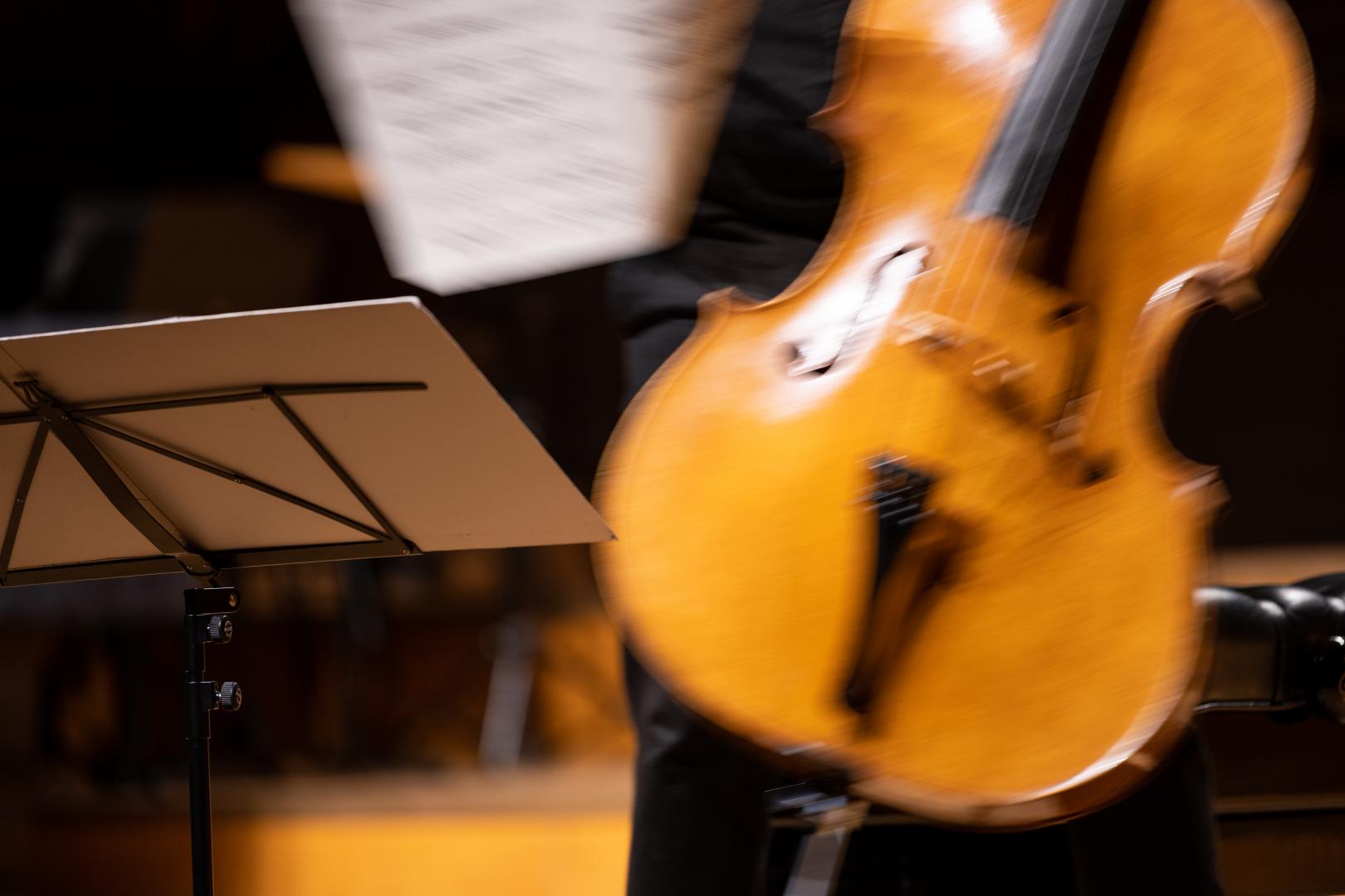 Verschwommenes Bild eines Violoncellos, eines Notenständers und Noten