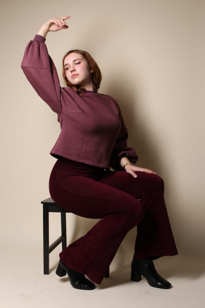 Anna Turowez. Auf einem Stuhl sitzend. Ein Arm schwingend.