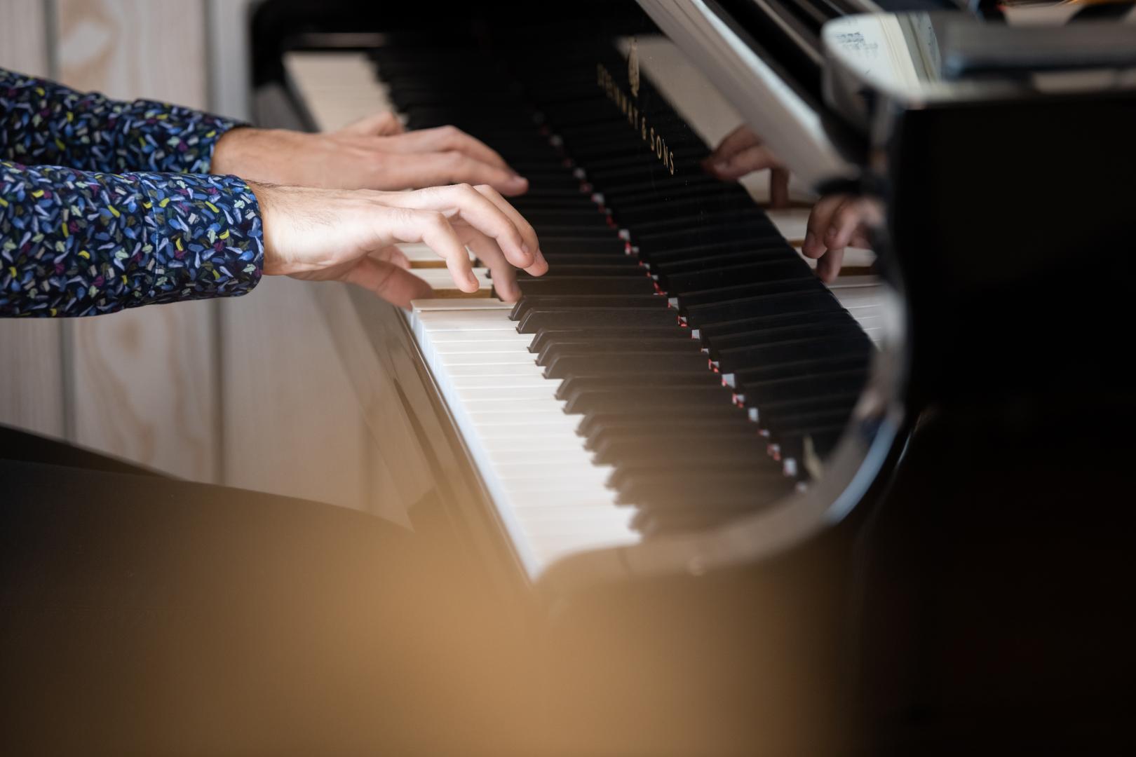 Nahaufnahme der Hände eines Pianisten am Klavier