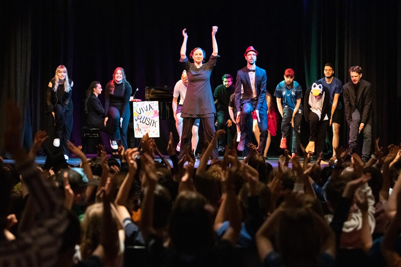 Mitmachmusical auf der Bühne, begeisterte Kinder im Pzblikum