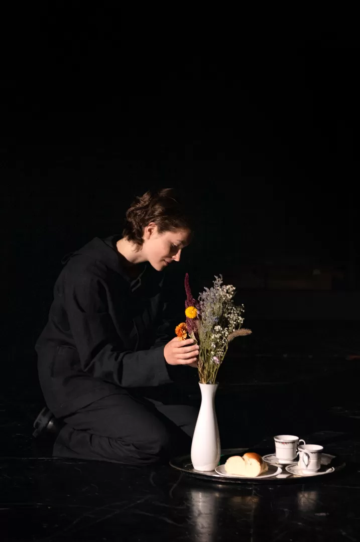 Schauspielerin, die bunte Feldblumen in einer Vase arrangiert.