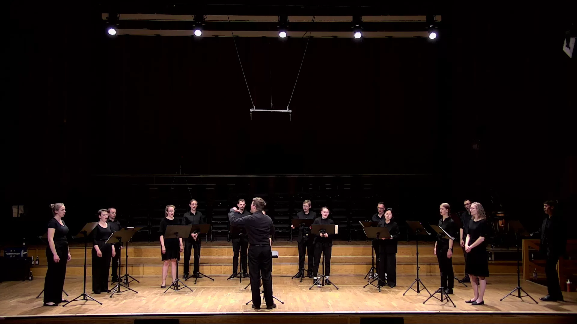 Blick auf die Konzertbühne; ein Student dirigiert den Chor