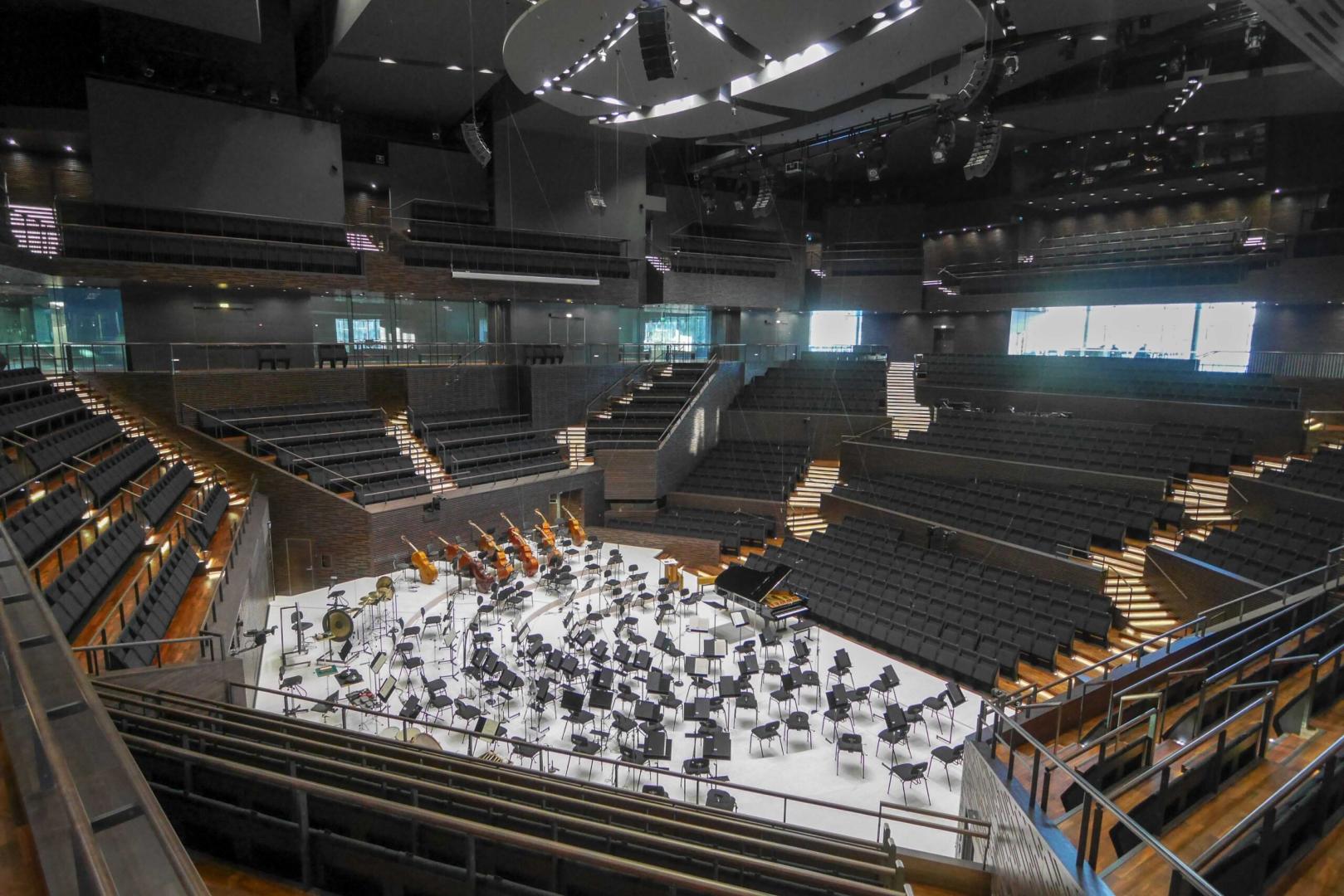 Blick in den leeren Konzertsaal des Helsinki Music Center, die Bühne ist für ein Orchester eingerichtet, die Plätze für Publikum leer.
