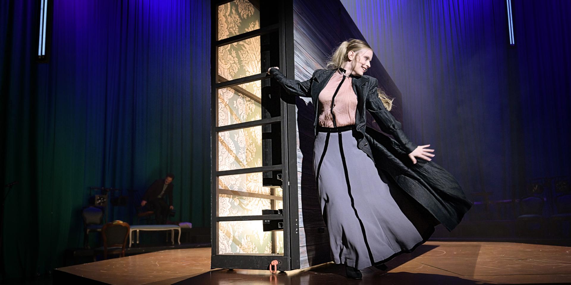 Frau in langem Kleid, tanzend und lächelnd.