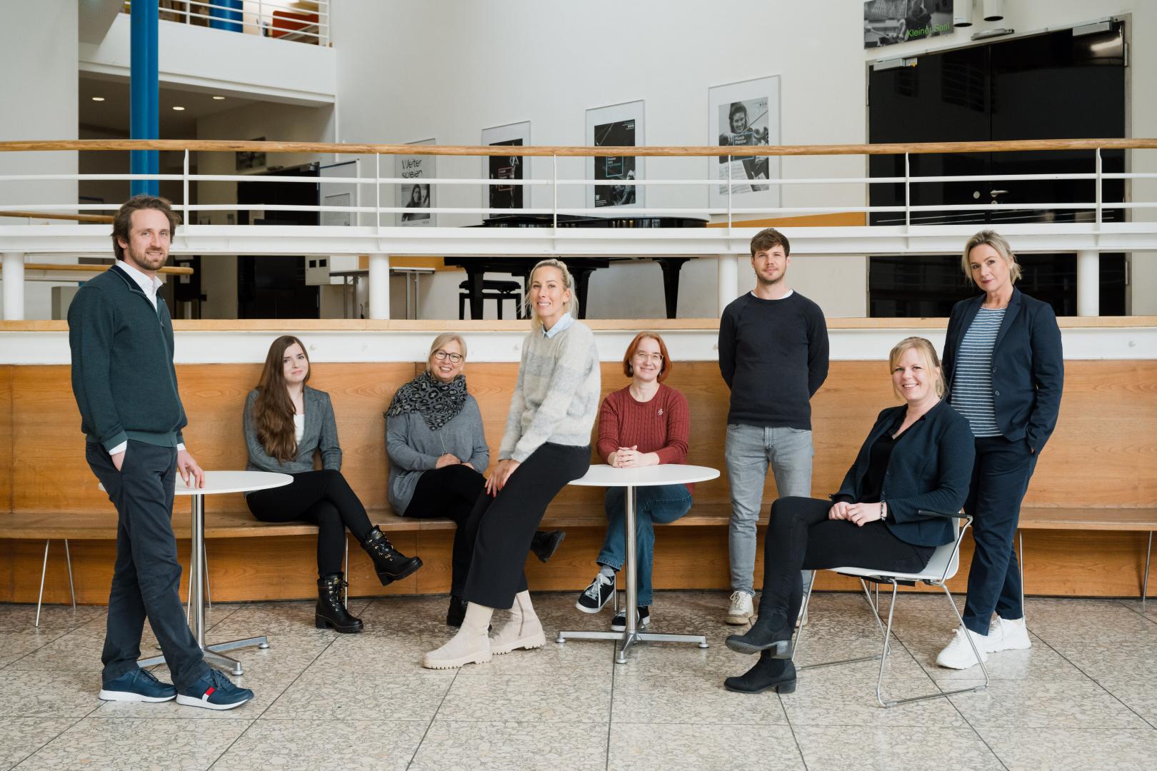 Gruppenbild der 8 Mitarbeiter*innen der Personalabteilung im Foyer der HfMDK Frankfurt