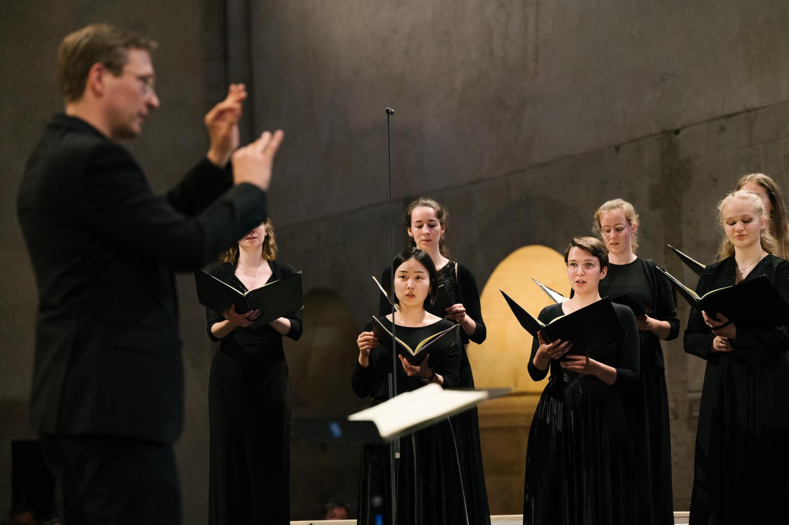 Konzert des Kammerchors im Kloster Eberbach. Im Hintergrund Sängerinnen, im Vordergrund (unscharf) Prof. Florian Lohmann.