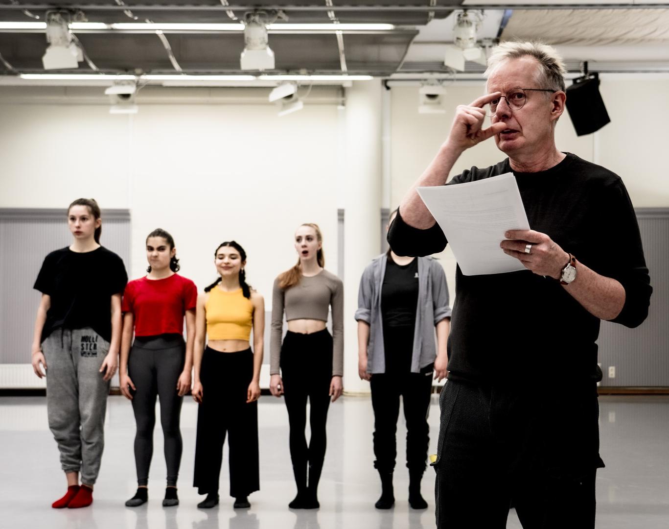 Szene aus dem Tanzunterricht, vier Studierende stehen in einer Reihe im Hintergrund. Im Vordergrund Prof. Dieter Heitkamp.