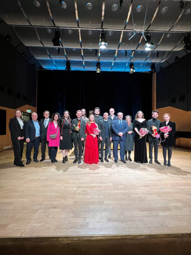 Gruppenfoto der Mitwirkenden des Benefizkonzerts auf der Bühne.