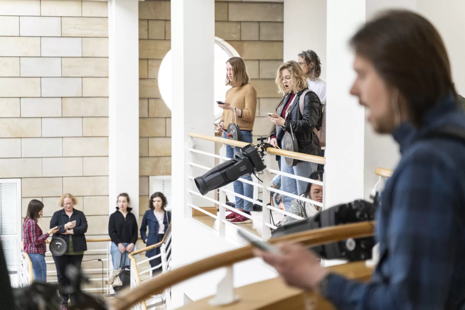 Sänger*innen mit Smartphones im Foyer der HfMDK Frankfurt