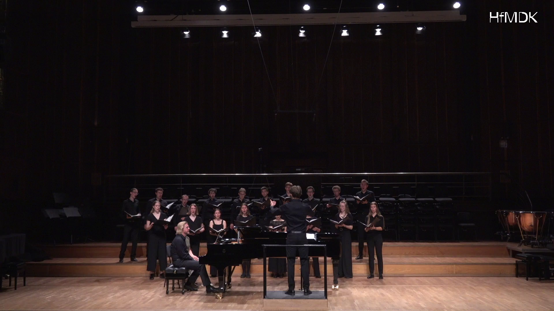Frontalansicht: Student dirigiert Chor