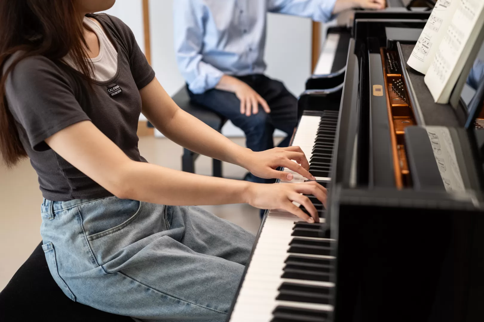 Klavier-Einzelunterricht: Nahaufnahme der Hände einer Pianistin am Flügel.