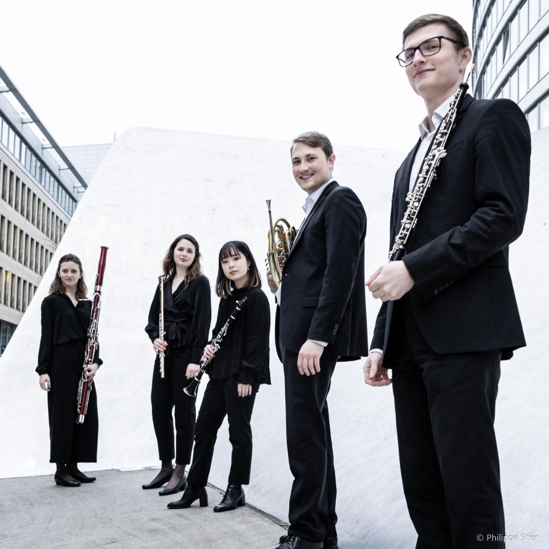 Gruppenfoto eines Bläserquintetts mit Instrumenten