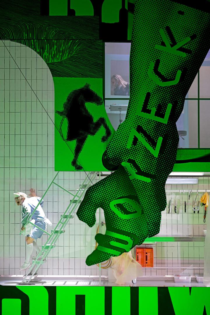 Bühne mit dem großen Schriftzug "Woyzeck", darin zwei Personen.