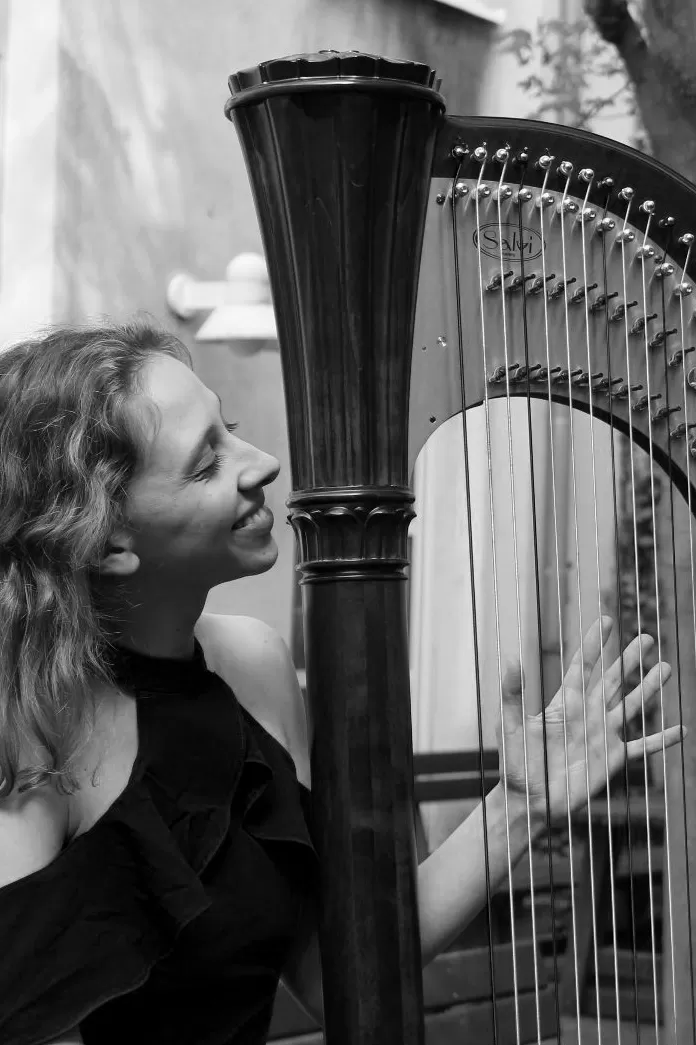 Schwarz-weiß Bild einer Harfenistin mit ihrem Instrument