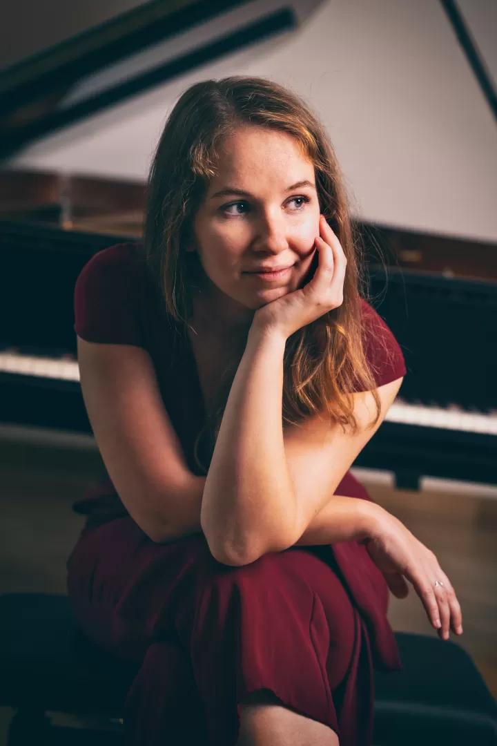 Porträt von Gesa Behrens, die vor einem Flügel sitzt