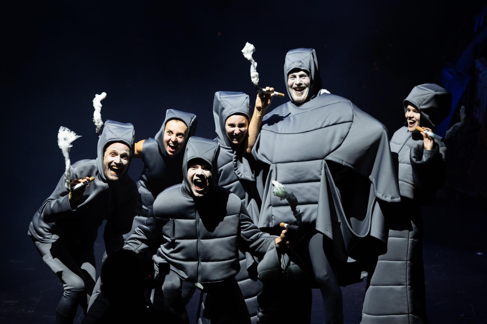 Gruppe schwarz gekleidetet und rauchender Personen.