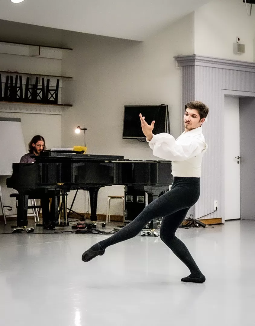 Ein Student tanzt Ballett und wird am Klavier begleitet.