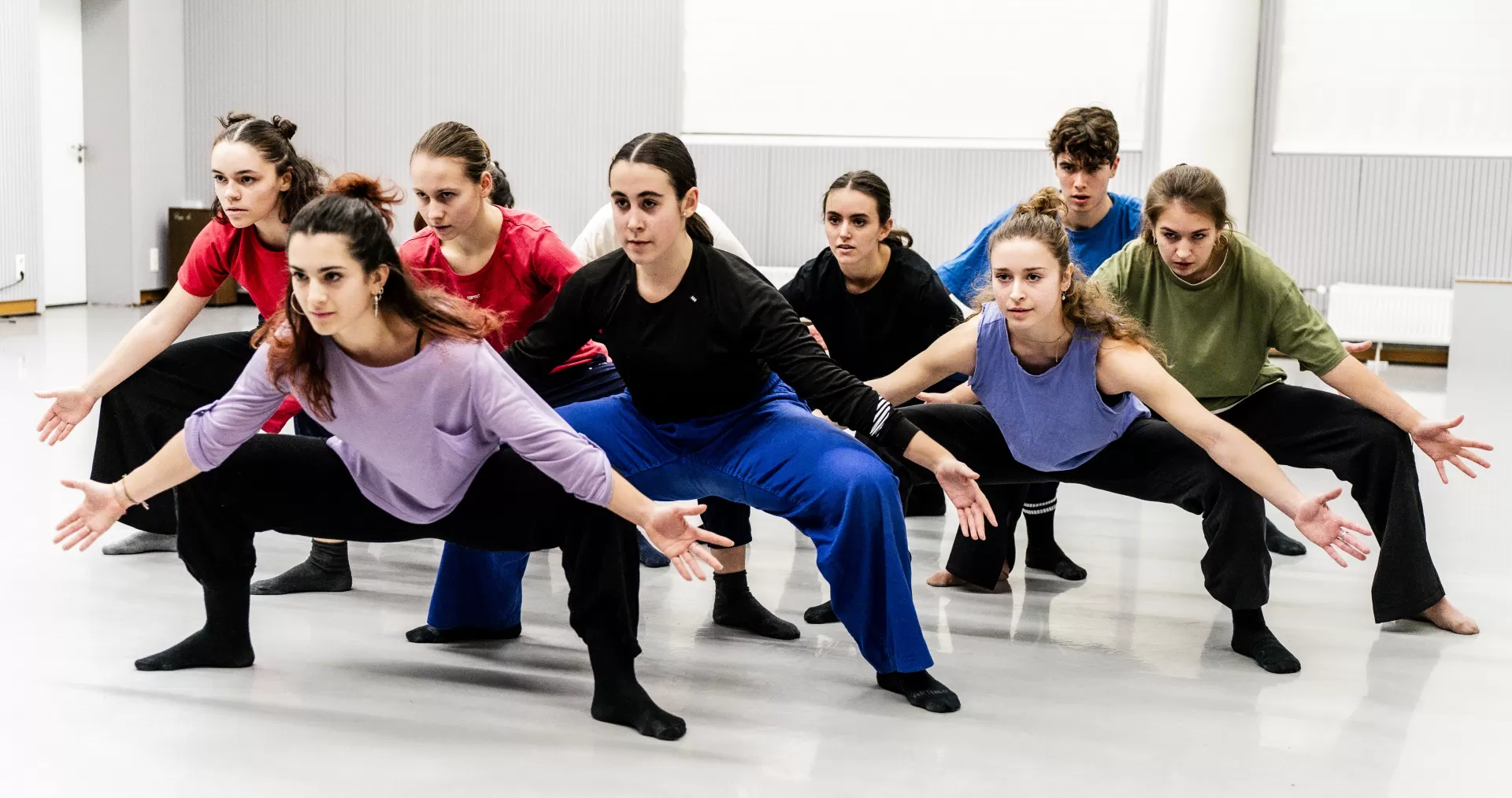 Tänzerinnen in einer Dreiecksformation im grand plié.