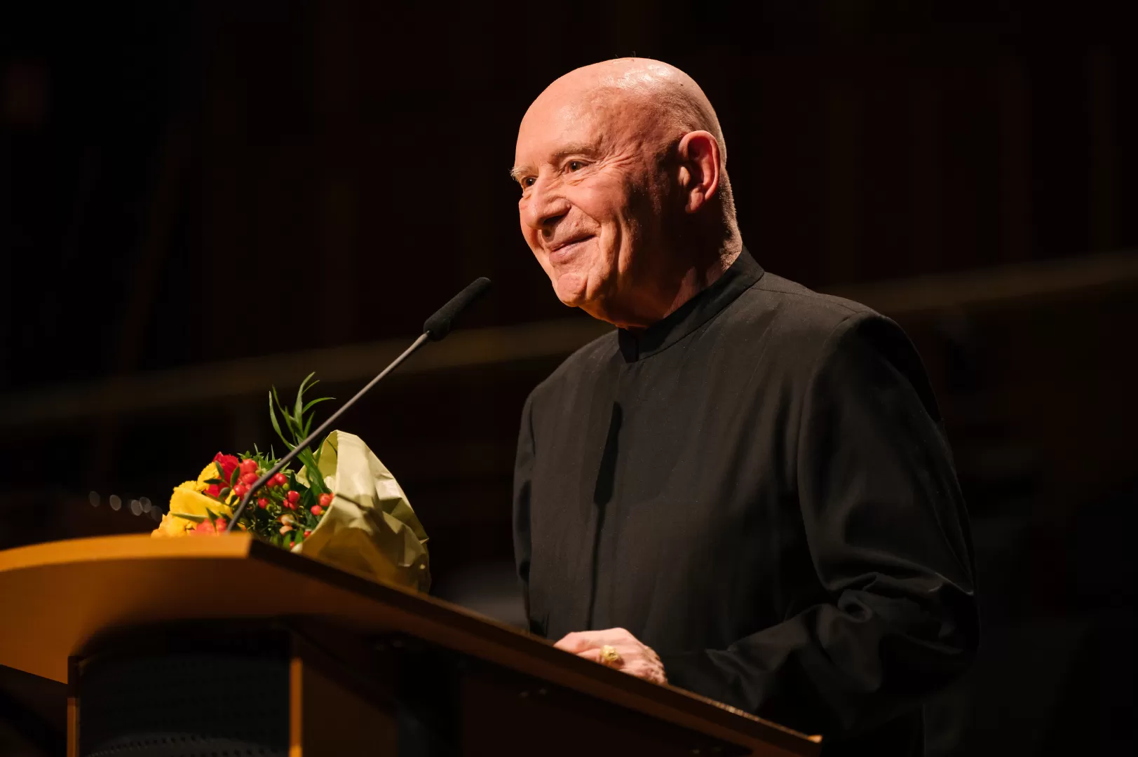 Christoph Eschenbach am Rednerpult mit einem Blumenstrauss
