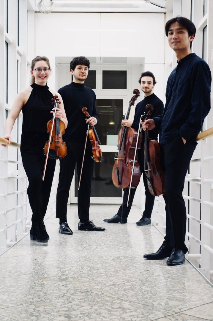 Die vier Musiker*innen des Raròn Quartets mit ihren Instrumenten in einem hellen Raum