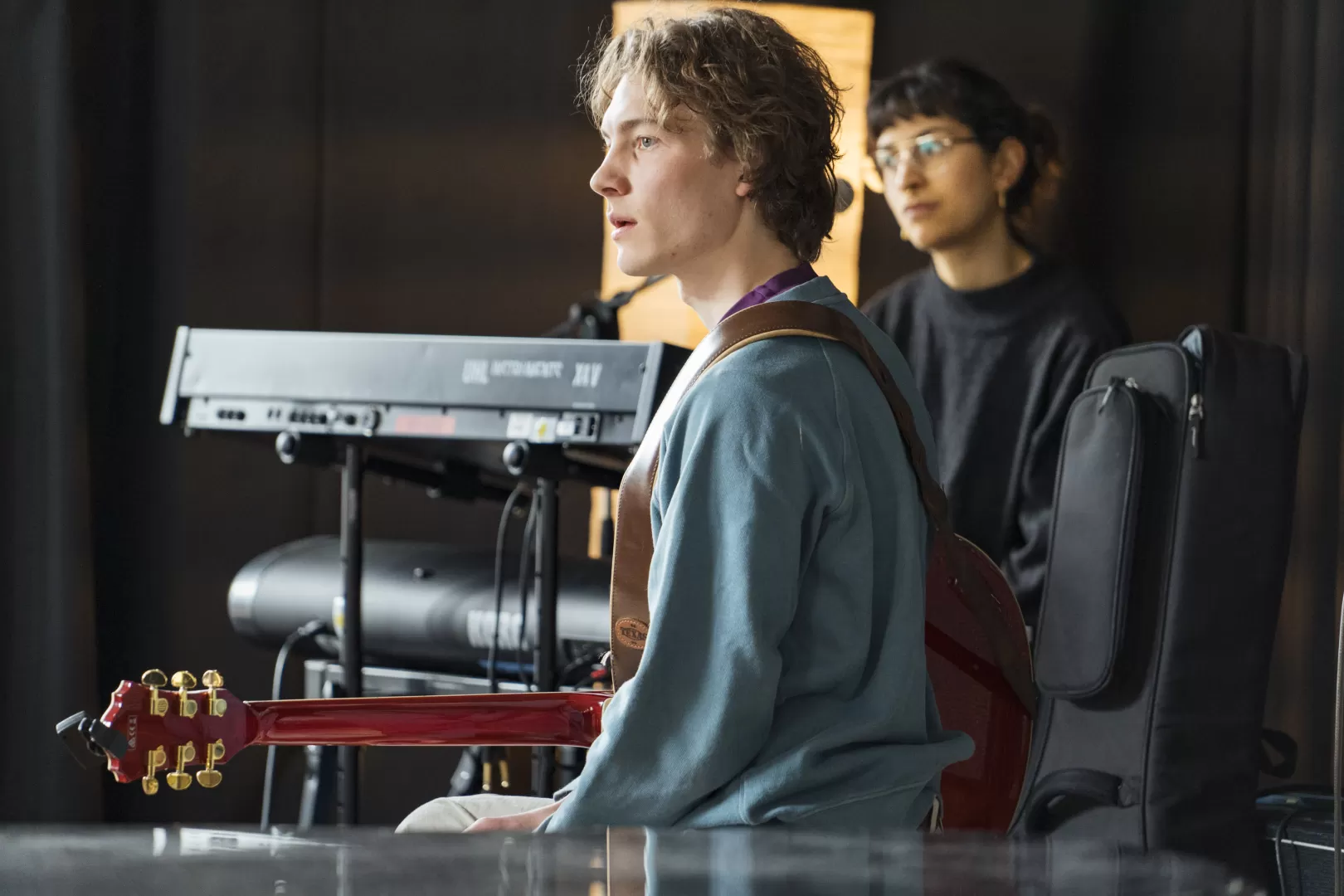 Der Gitarrist von NURIA NOBA & BAND hört im Coaching aufmerksam zu. Ebenso die Sängerin im Hintergrund.