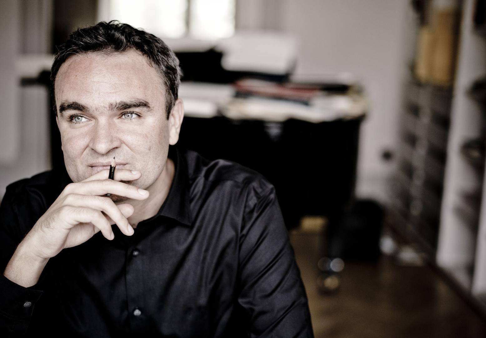 Der Komponist Jörg Widmann in nachdenklicher Pose an einem Schreibtisch