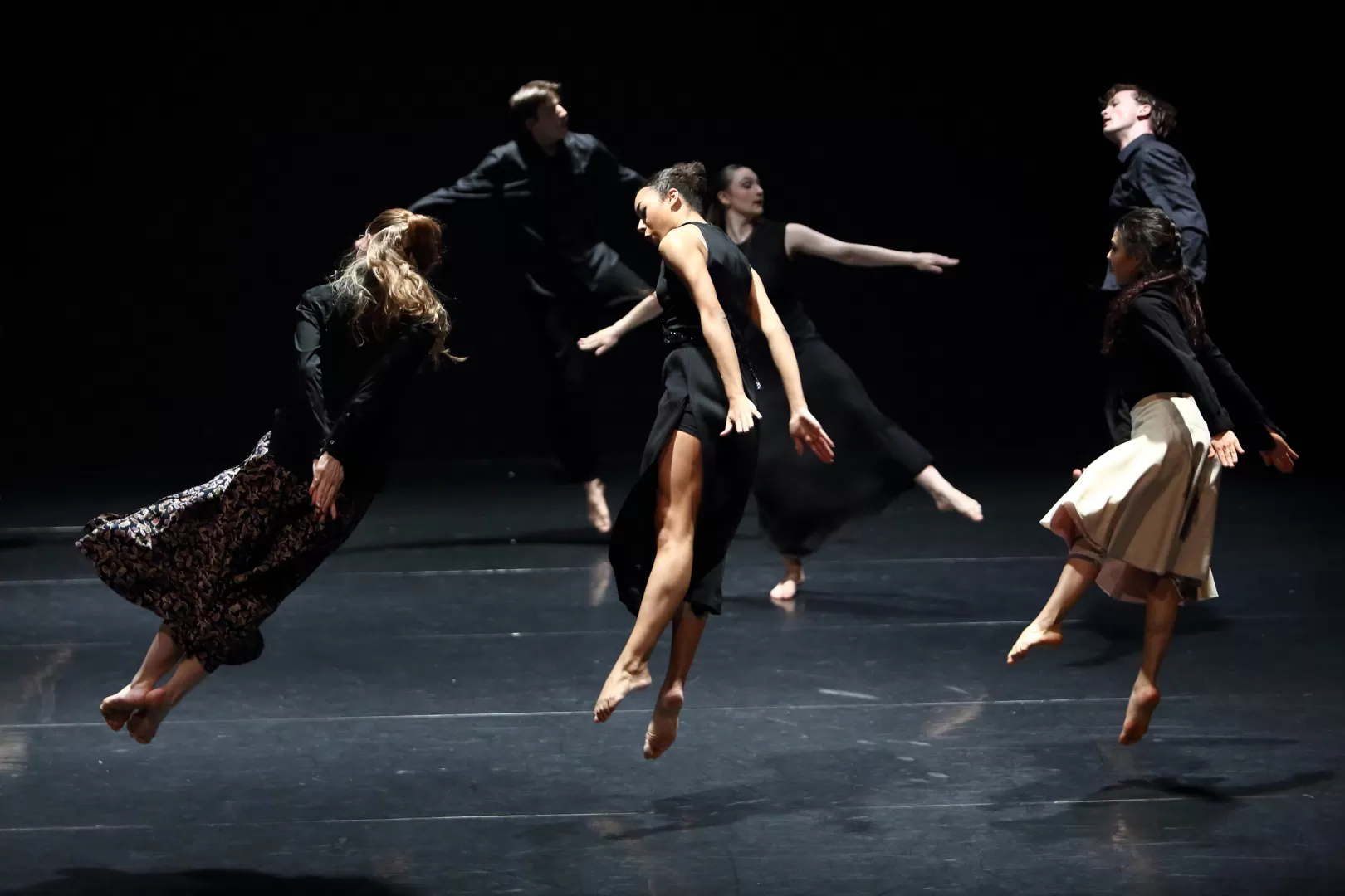 Mehrede tanzende Personen, die mitten im Sprung fotografiert sind und zu fliegen scheinen.