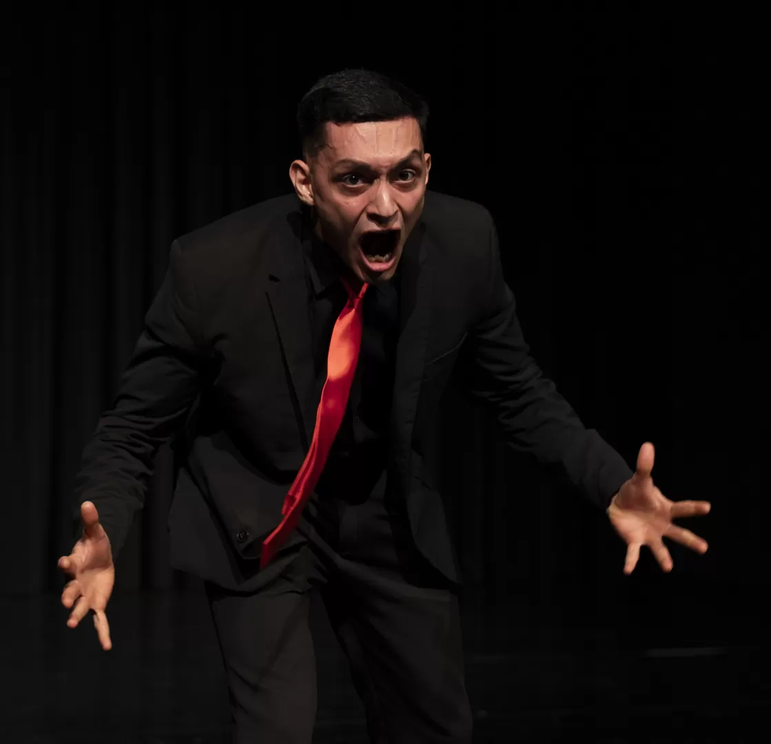 Ein Mann im schwarzen Anzug schreit.