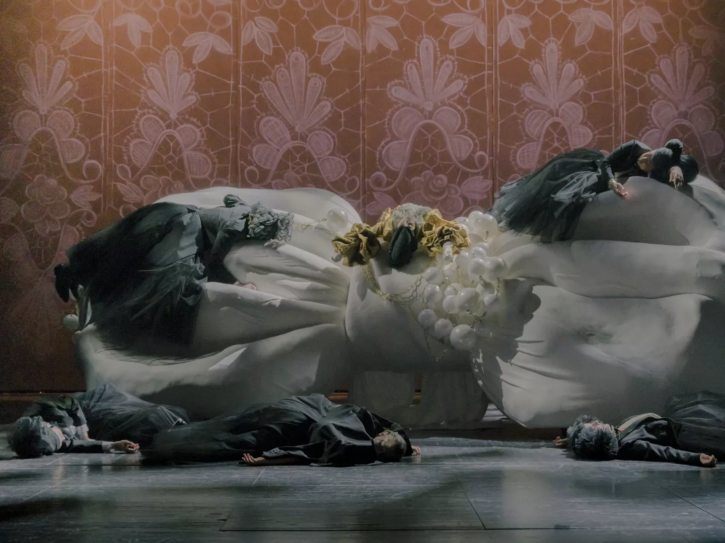 Darsteller*innen aus Die Fledermaus liegen auf dem Boden und auf dem Bühnenelement, scheinbar erschöpft