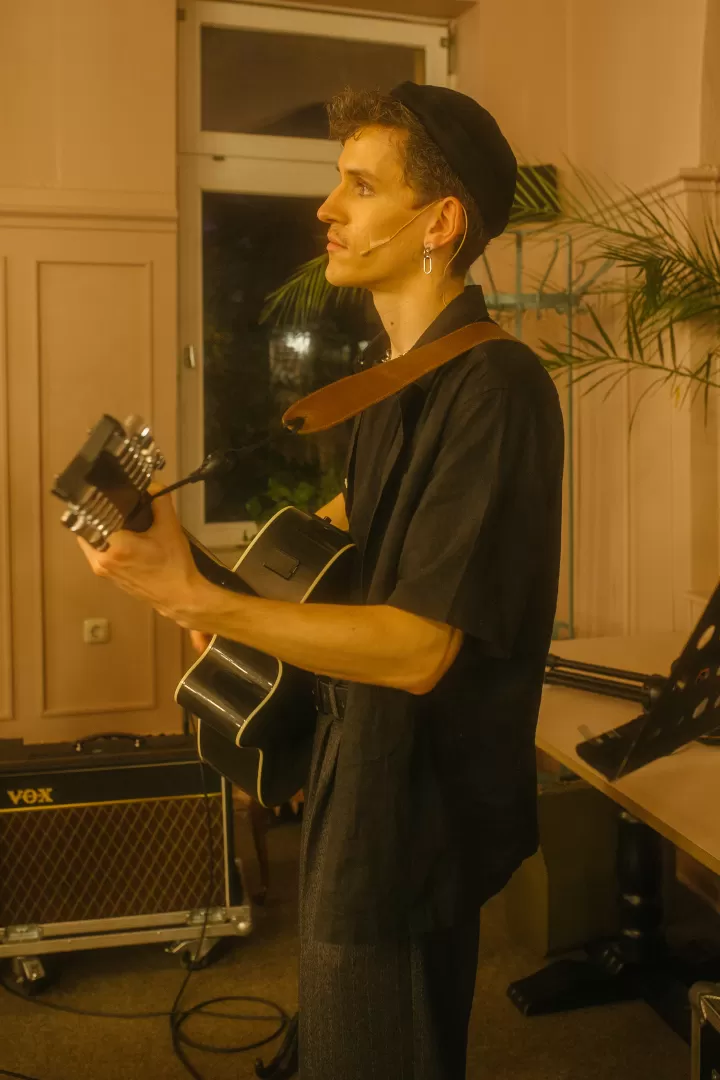Ein Mann mit Gitarre in einem Café.