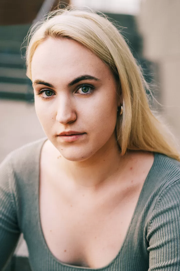 Eine Frau mit blonden Haaren in einer hellgrünen Bluse