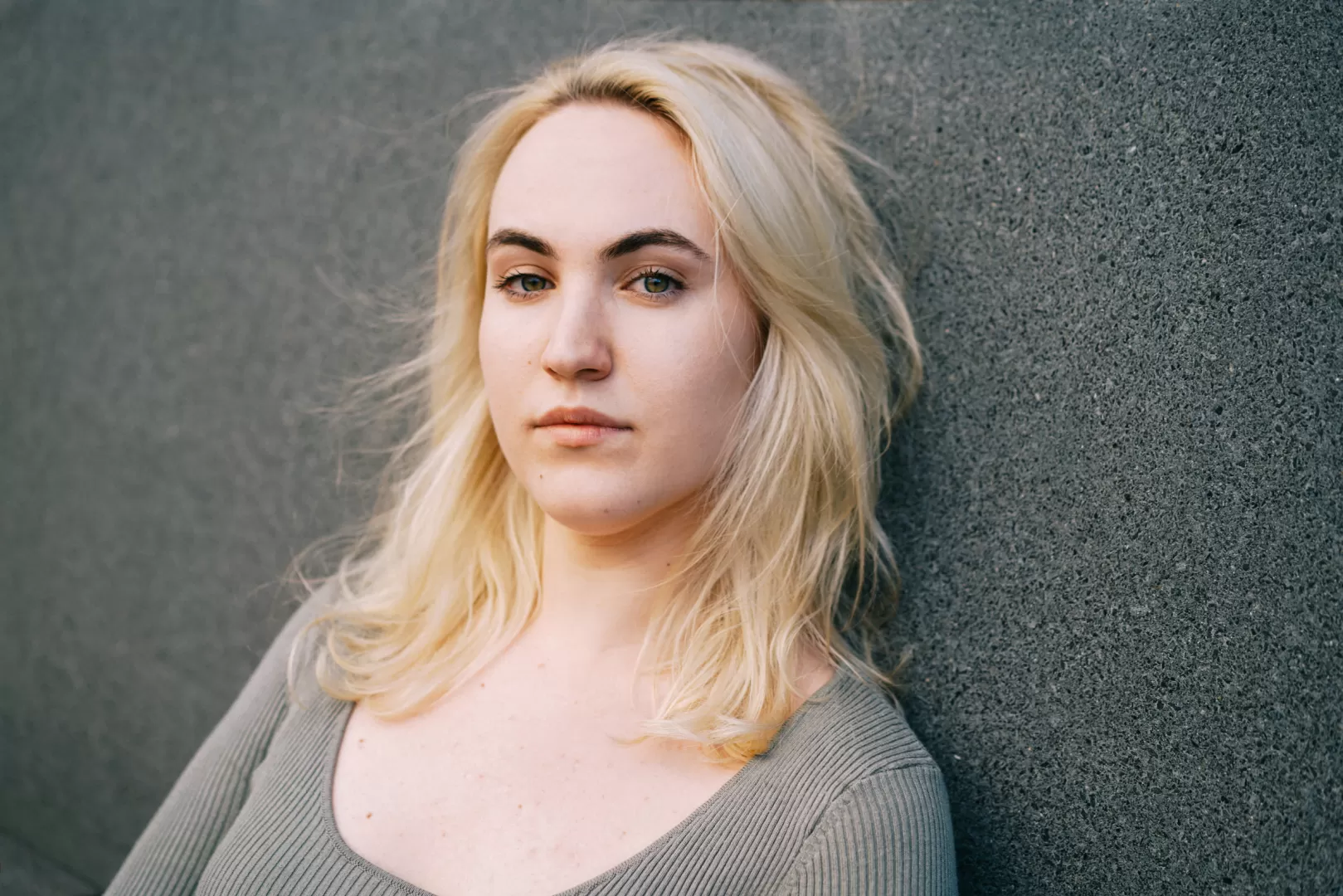 Eine Frau mit blonden Haaren lehnte an der Wand