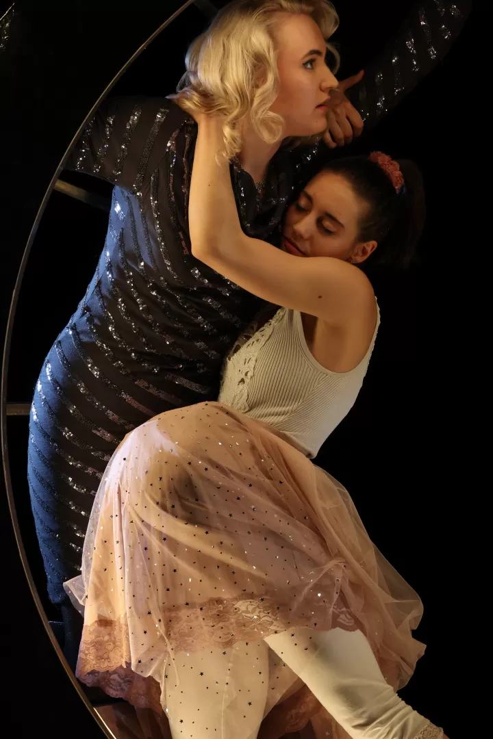 Ein Mädchen schläft und stürzt sich auf eine Frau in einem blauen Kleid und mit lockigem Haar